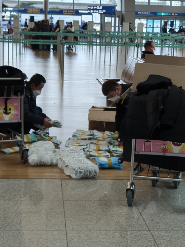 인천공항 바닥에 앉아 관세청 제재를 피하기 위해 마스크를 나누고 있는 중국 보따리상 (사진=환경경찰뉴스)