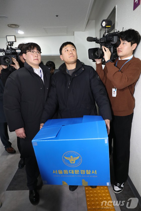 청량리4구역 재개발 비리 의혹을 수사 중인 경찰이 23일 서울 동대문구청 주택과에 대한 압수수색을 마친뒤 압수품이 든 상자를 들고 나서고 있다.